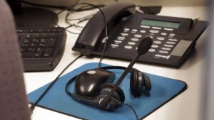 Schreibtisch mit Telefon, Tastatur, Maus und Head-Set