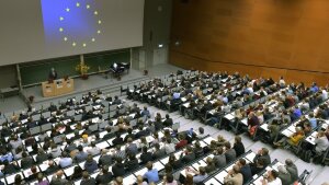 Participants sit in the lecture hall and follow an event