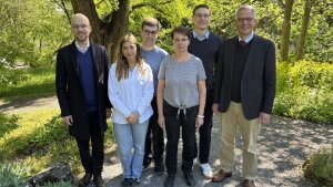 Team des Lehrstuhls Ohler im Mai 2025 vor Bäumen und Sträuchern
