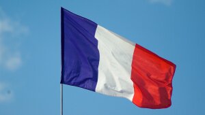 Die Flagge Frankreichs weht vor einem fast wolkenlosen Himmel